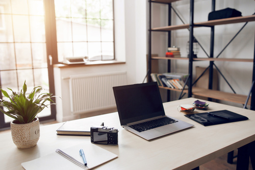 Modern desk with laptop and notepad